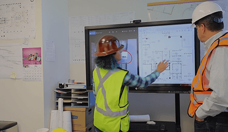 Construction workers using SKYSITE SmartScreens for collaboration